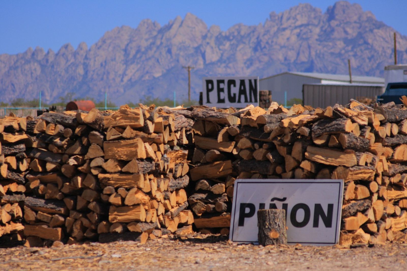 Split piñon firewood stacked at the QFM yard
