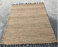 Light tan area rug with brown tassels