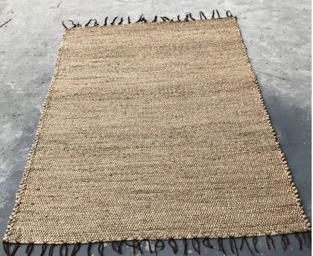 Light tan area rug with brown tassels